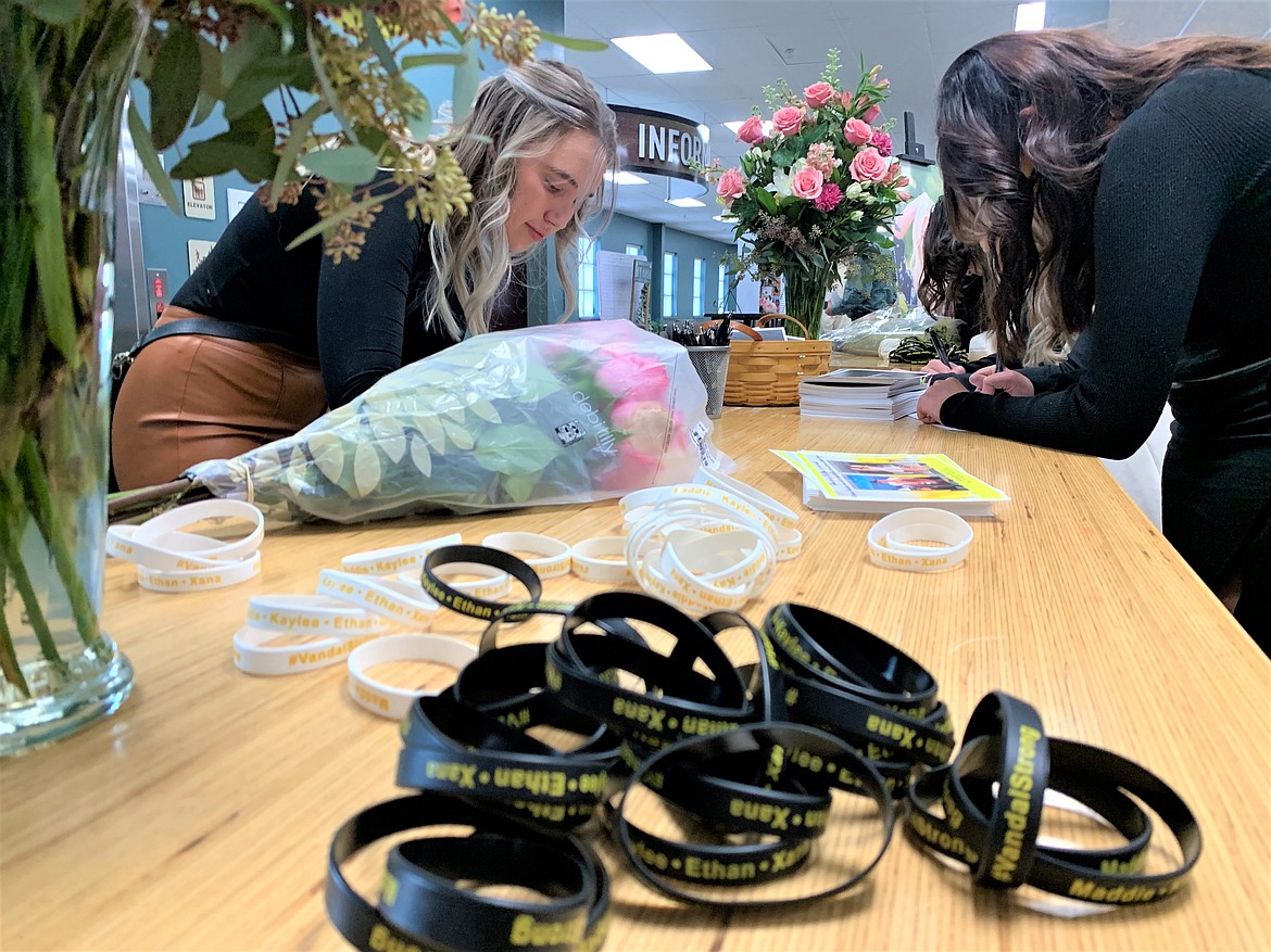 A University of Idaho student writes on a card following Friday's celebration of life at Real Life Ministries for the four slain UI students.