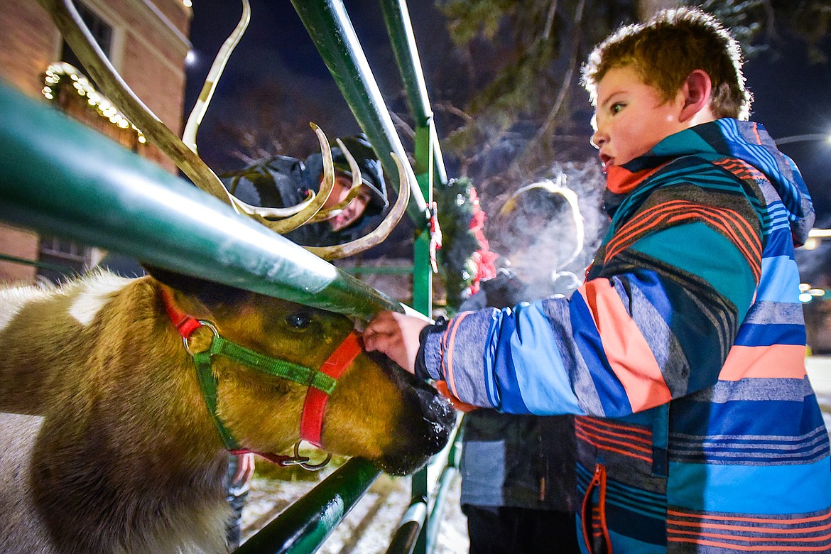 Hunter Toole marvels at a reindeer's antlers as he gets a chance to pet it outside Johnson-Gloschat Funeral Home and Crematory during the Downtown Kalispell Holiday Stroll & Tree Lighting on Friday, Dec. 2. (Casey Kreider/Daily Inter Lake)