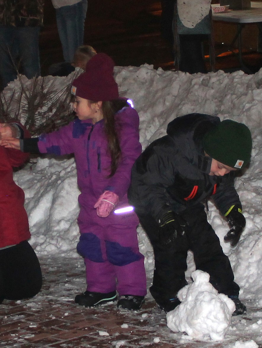 Three-year-old Brynlee Suarez, left, and her 6-year-old brother Braxton explore the snow in Sinkiuse Square Friday before the Ag Appreciation Parade.