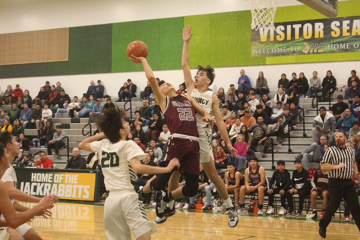 Wahluke’s River Buck (21) goes up for a shot against Quincy’s Pierce Bierlink in Friday’s 71-53 Quincy win.