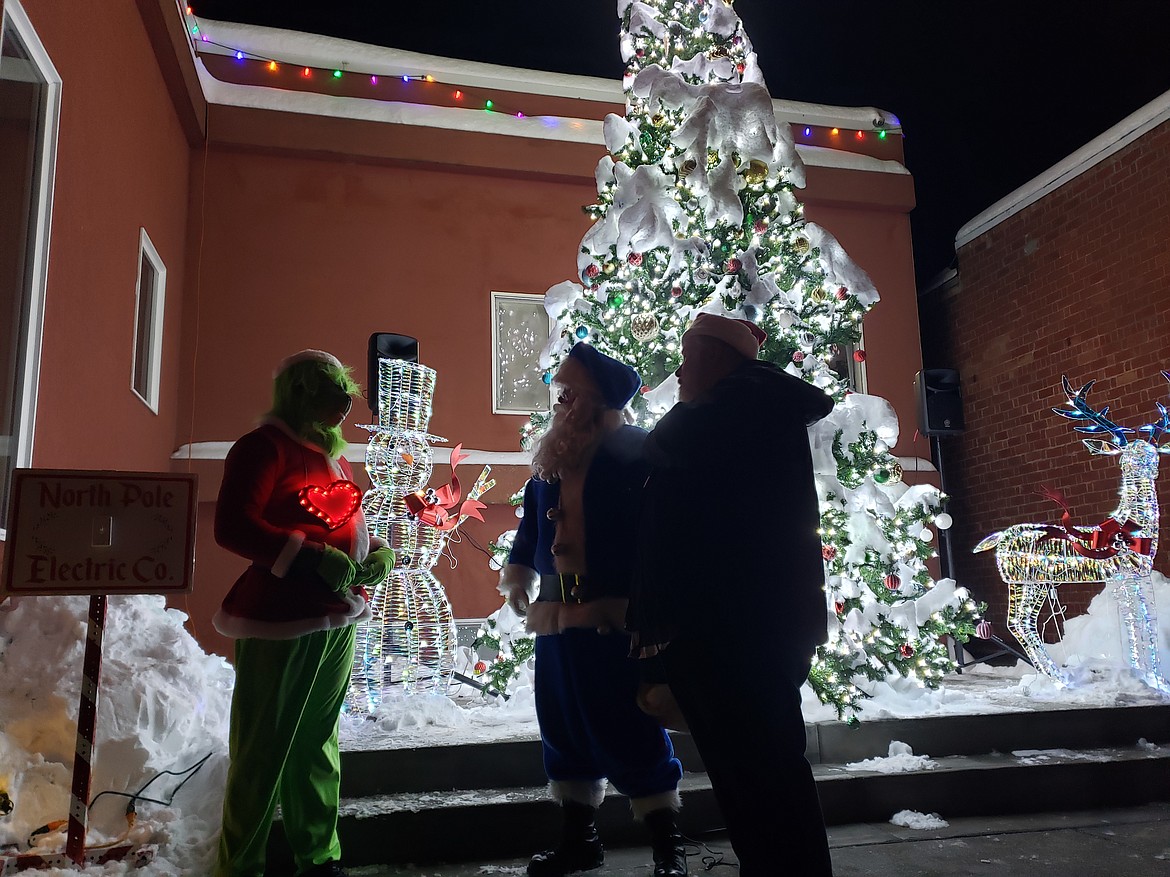 Rathdrum Mayor Vic Holmes and Santa congratulate the Grinch on his large heart when he allows the tree before city hall to stay lit Saturday night for all to see.