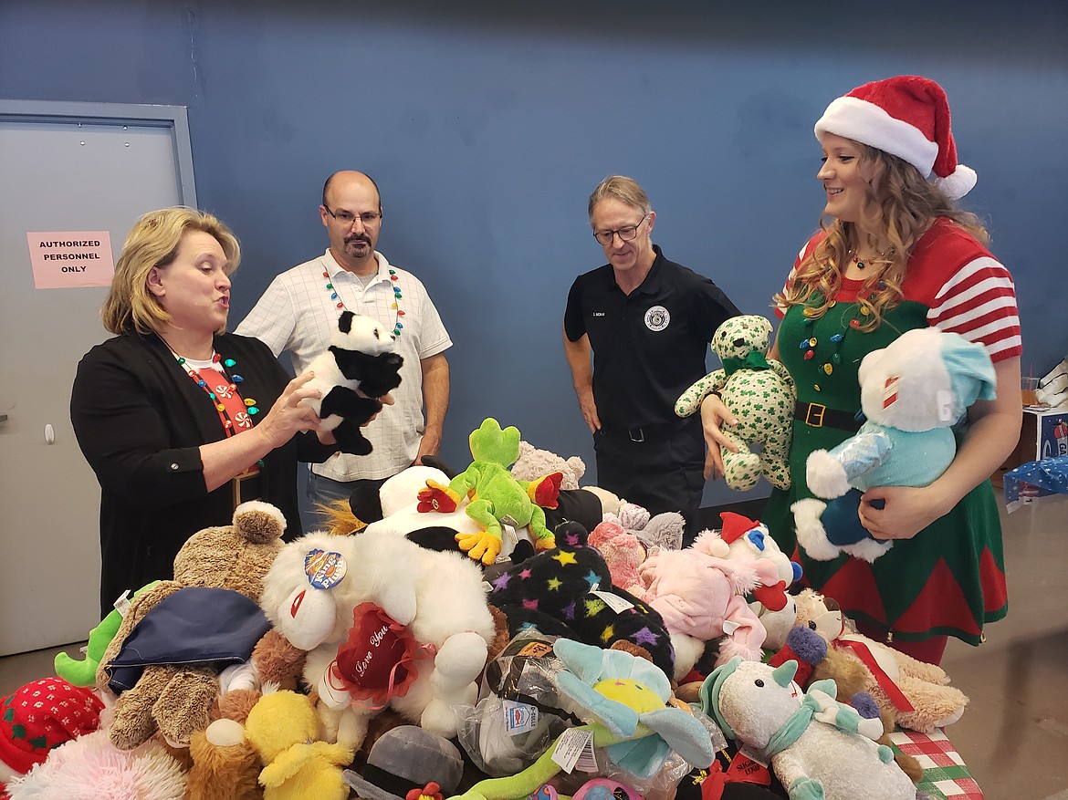 Volunteers (from left) Marla and Steve Montagne, Steve Moran, and Andrea Shanklin make sure some of the stuffed animals are soft enough for children to enjoy at the Holidays and Heroes event on Dec. 4 in the Greyhound Park and Event Center. Their goal is to give kids a special day centered around making them happy.