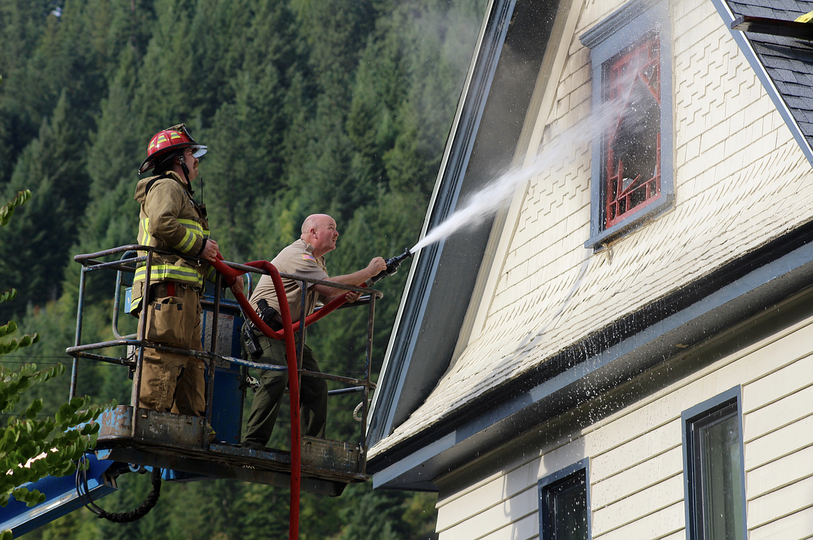 Shoshone County Fire District No. 1 Firefighter Jack Long (left) and Sheriff Mike Gunderson attack a 2019 structure fire in Wallace from a Genie Lift that was originally being used for roofing work on the home.