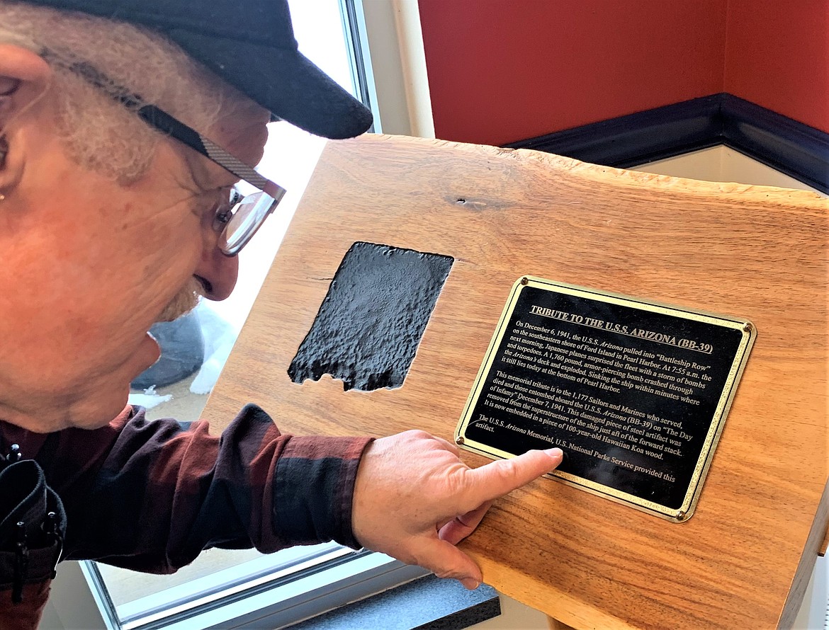 Veteran Bob Shay reads the "Tribute to the U.S.S. Arizona" that stands at Post Falls American Legion on Tuesday.