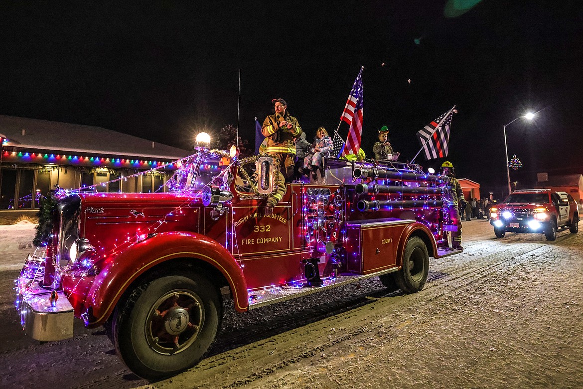 The old Hungry Horse Volunteer Fire Truck passes through the Night of Lights Parade on Friday, horn blasting. (JP Edge photo)