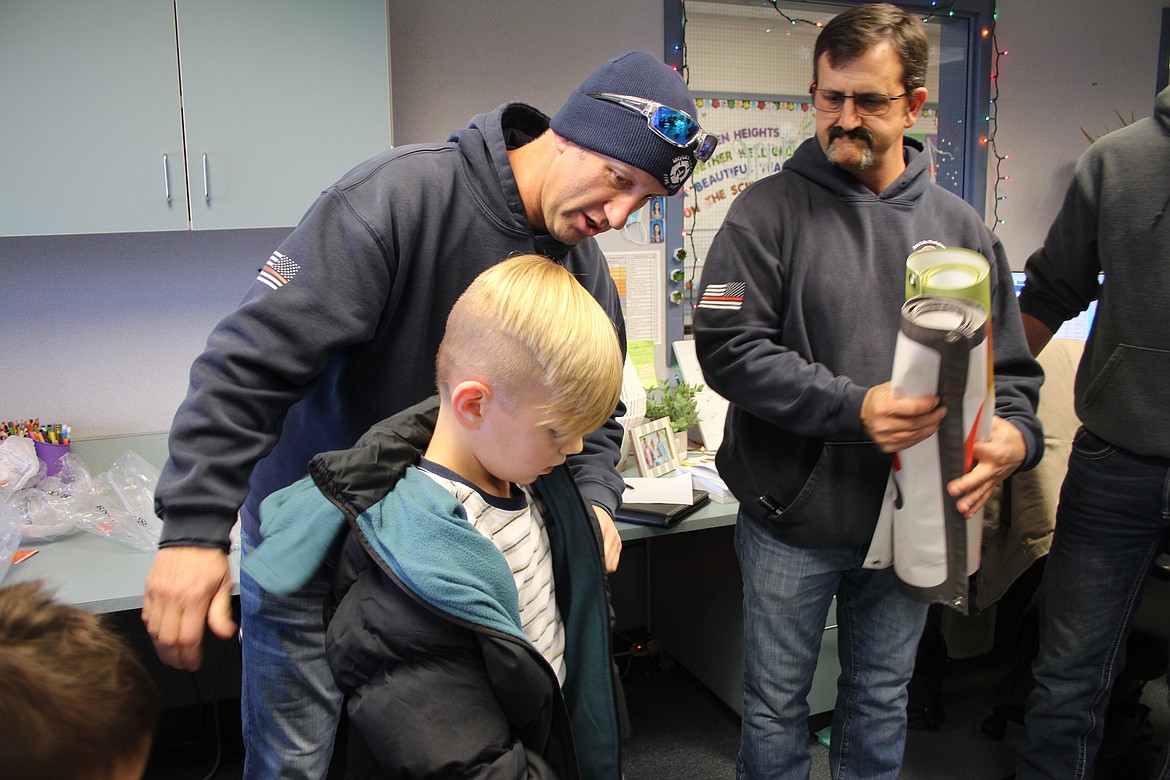 Brandon Burns, Moses Lake Fire Department battalion chief, checks the fit of Malikye Cook’s new coat during the Operation Warm presentation at Garden Heights Elementary Wednesday.