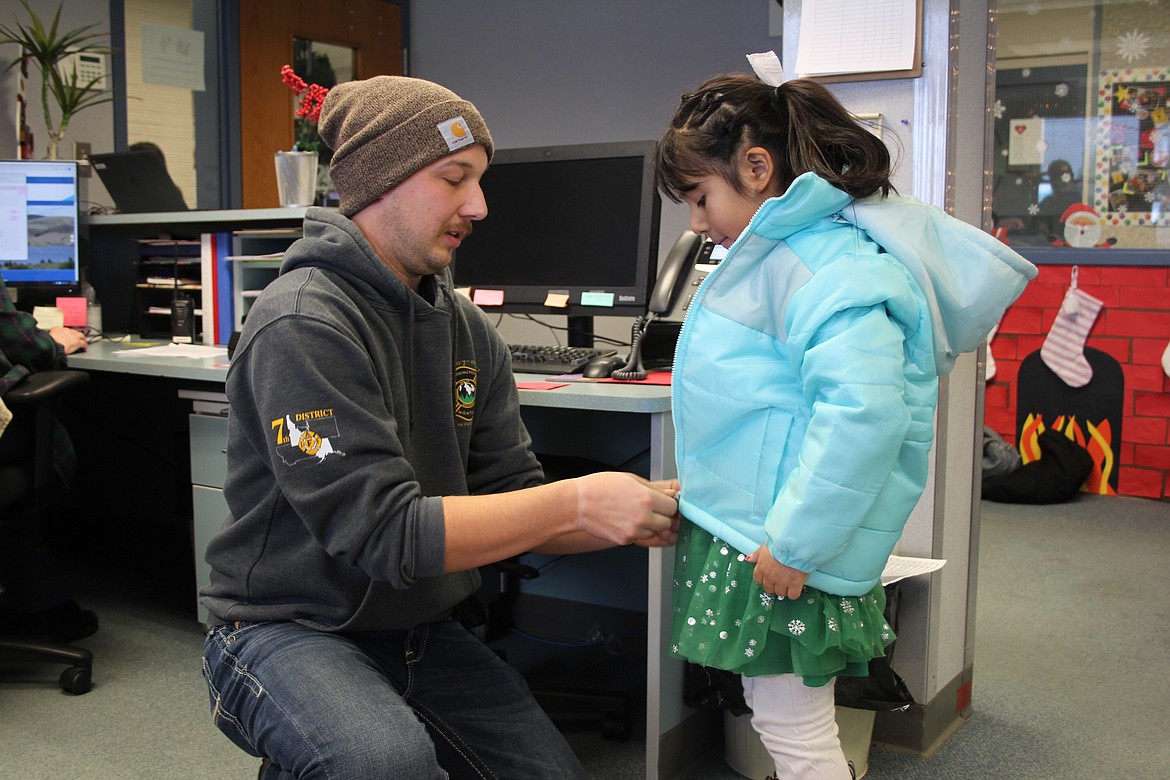 Garrett Fletcher zips up a new coat for Adalina Flores during the Operation Warm giveaway Wednesday.