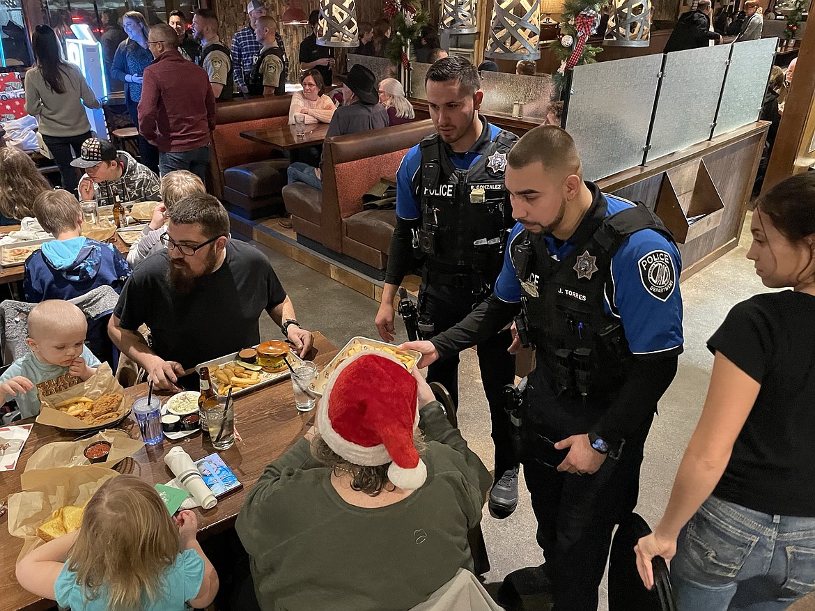 Warden Police Department officers Ricardo Gonzalez (top) and Joel Torres serve customers at Rock Top Burgers and Brew Wednesday evening as part of the eatery’s annual Tip-A-Cop fundraiser, which helped the WPD, Moses Lake Police Department and the Grant County Sheriff’s Office raise money for this year’s Shop With a Cop.