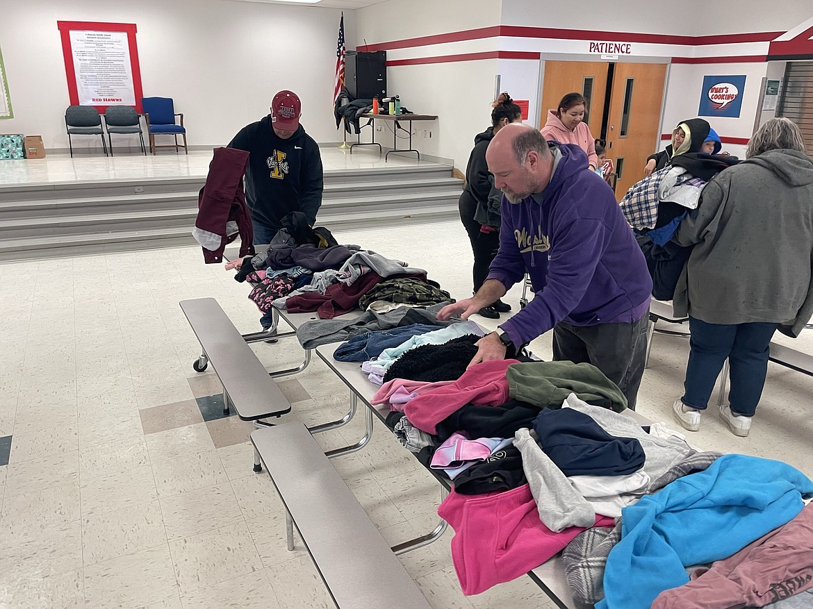 James Yonko, assistant principal at Vanguard Academy, and Jeremy Nolan, a member of the Rotary Club of Moses Lake, sort through winter coats on Saturday.