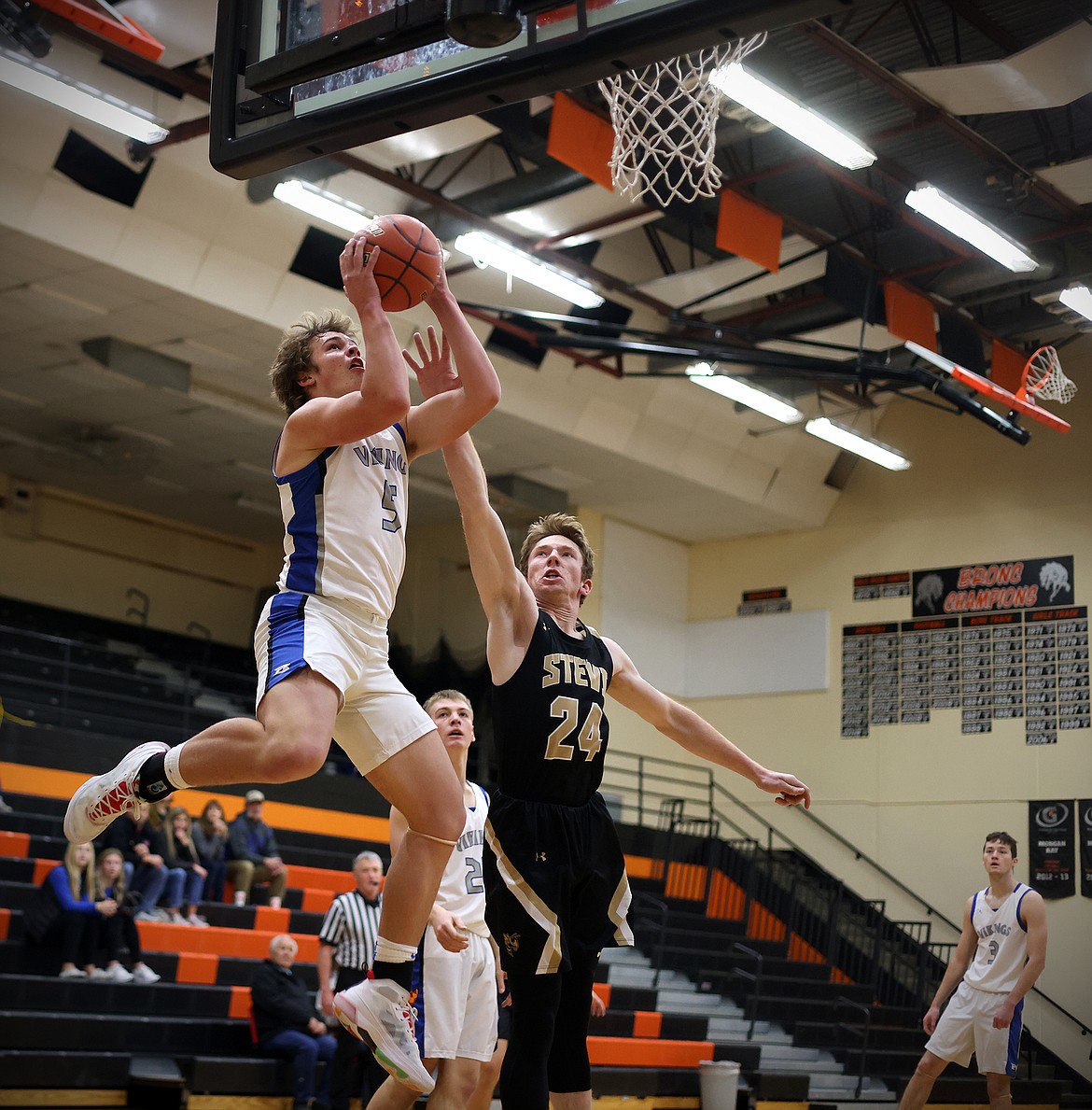 Bigfork's Eli Thorness jumps past Stevensville's TJ Brown to complete an alley-oop play for the Vikings in the first quarter at the Frenchtown Tip Off Tournament on Friday, Dec. 9. (Jeremy Weber/Daily Inter Lake)