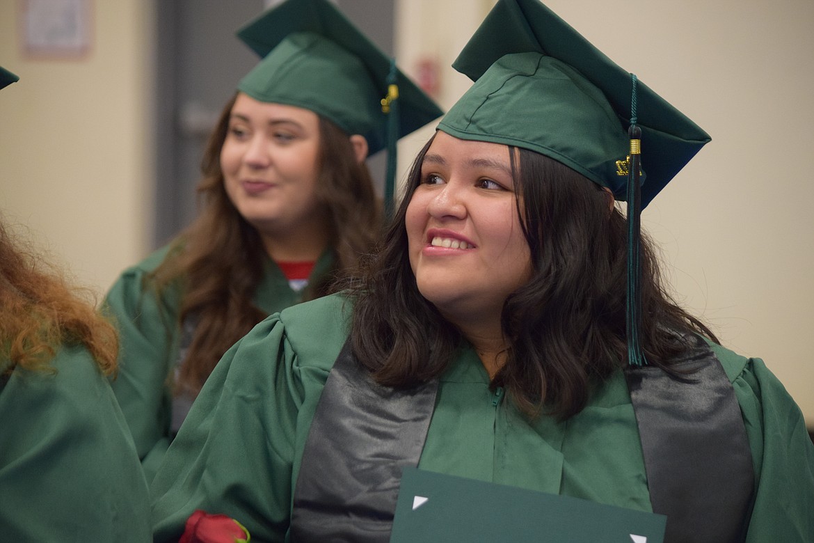 Yulia Orduno-Hernandez (front) and Suzanna Vargas (rear), two of this December’s graduates from the Columbia Basin Job Corps program, as they listen to commencement speakers during the center’s first public graduation ceremony in nearly three years on Friday.