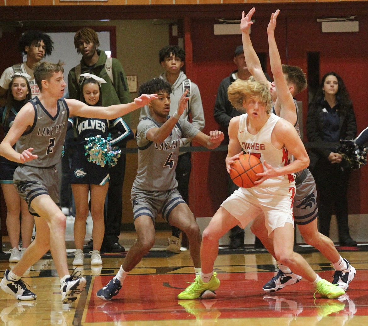 MARK NELKE/Press
Lake City's Justin Hill (2), Cason Miller (4) and Kolton Mitchell guard Liam Campbell of Owyhee on Saturday night at North Idaho College.