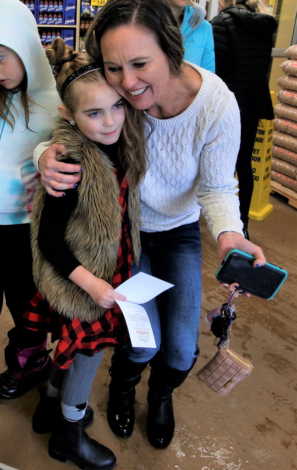 Heidi Vonlind gives Lola Haycraft a hug during the 7-year-old's food drive at Super 1 Foods in Hayden on Saturday.