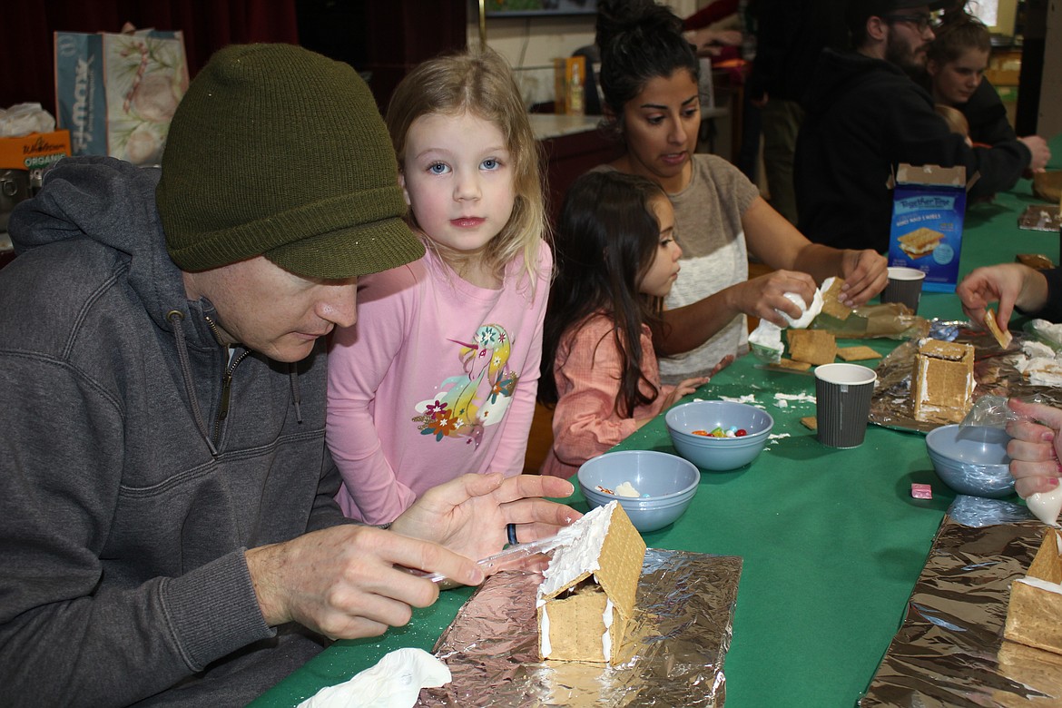 Parents were helpful to many of the young students building their first gingerbread house on Sunday in the Alberton School gymnasium. The 2-hour workshop was sponsored by the Alberton School Parents Teachers Student Association. (Monte Turner/Mineral Independent)