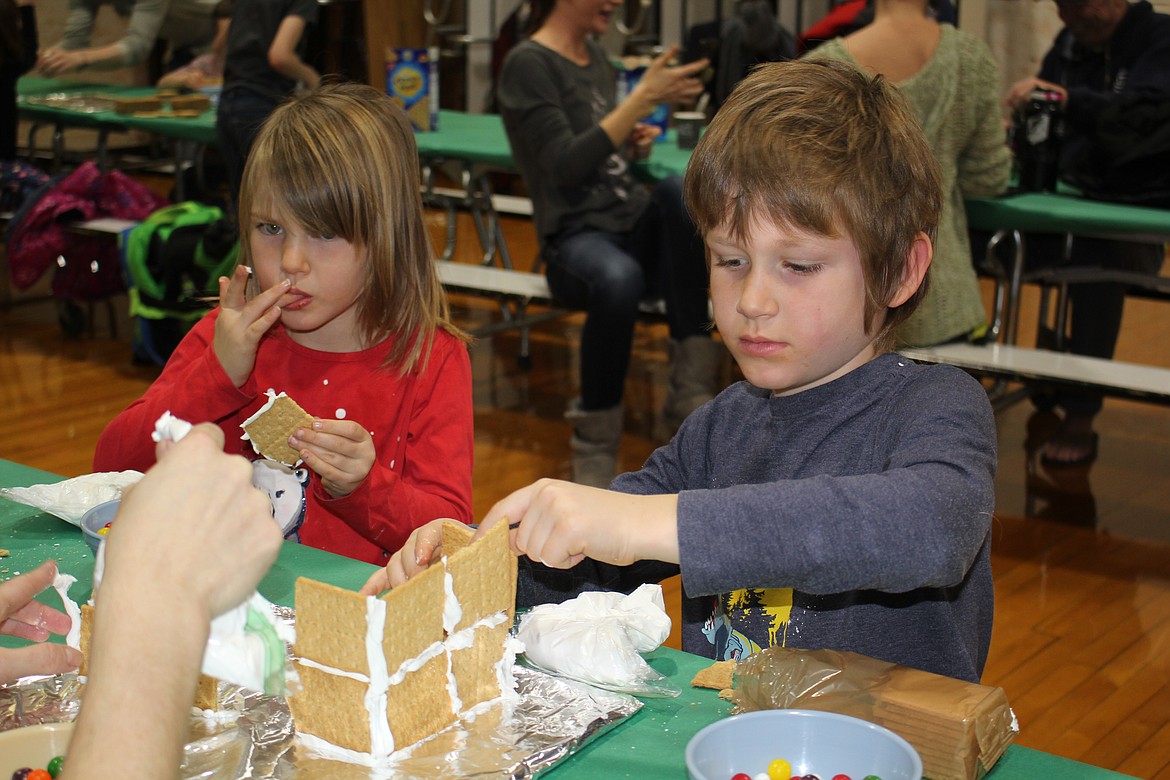 Some of the building materials were eaten during the Alberton PTSA gingerbread building workshop Sunday afternoon. But at the end of the 2 hours, dozens of families returned home with something they made together and probably ate together as well. (Monte Turner/Mineral Independent)