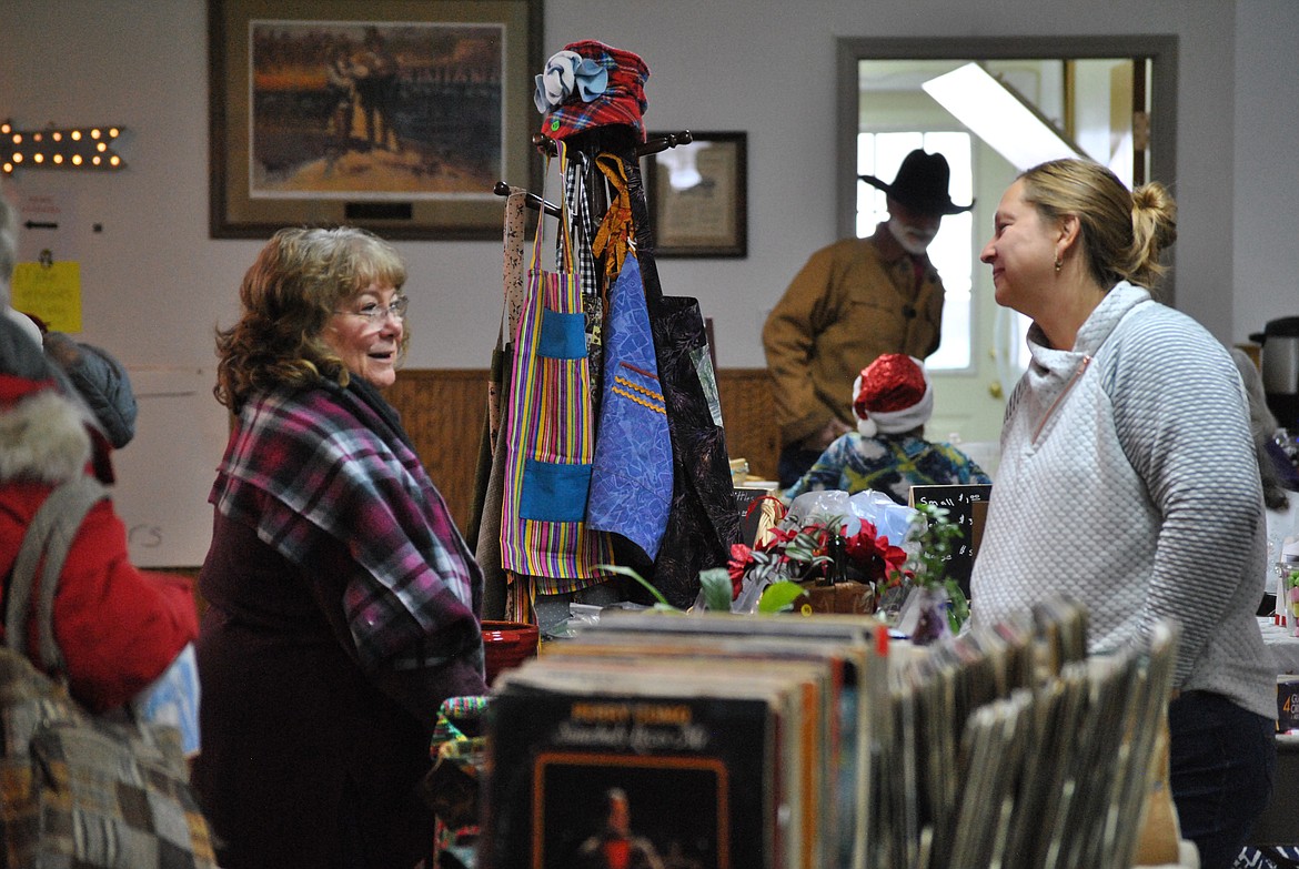 St. Regis resident Nikki Clyde catches up with vendor Becky Cannon while shopping at the annual Christmas Bazaar at the St. Regis Community Center. Eileen Wolff one of the organizers said, "It was a very busy day, lots of shoppers, and more vendors than years before!" Other rooms were opened up in the building to make extra space for sellers tables and booths. (Amy Quinlivan/Mineral Independent)