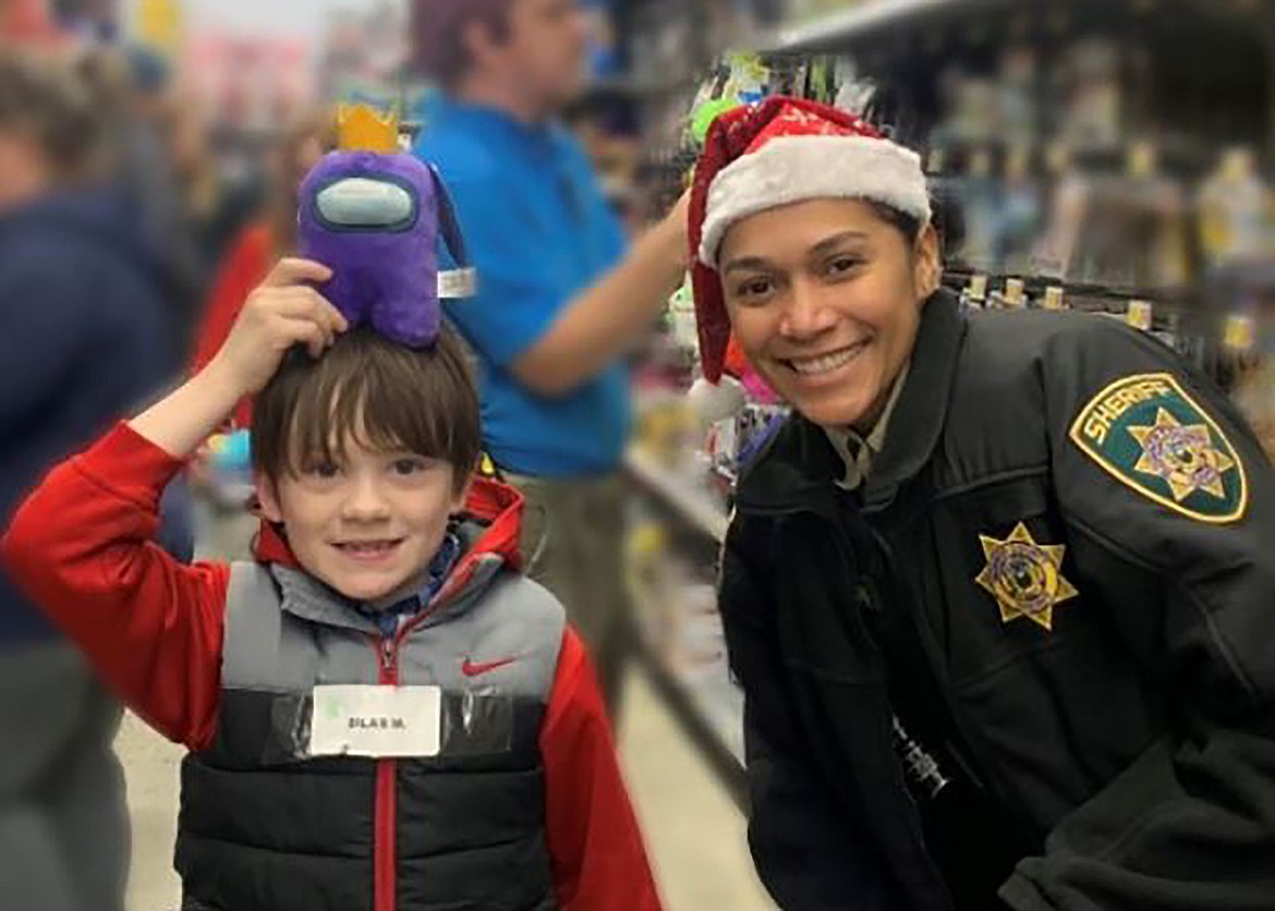 Bonner County Sheriff's Deputy Sullivan helps a local youth during last Saturday's "Shop with a Cop" event.