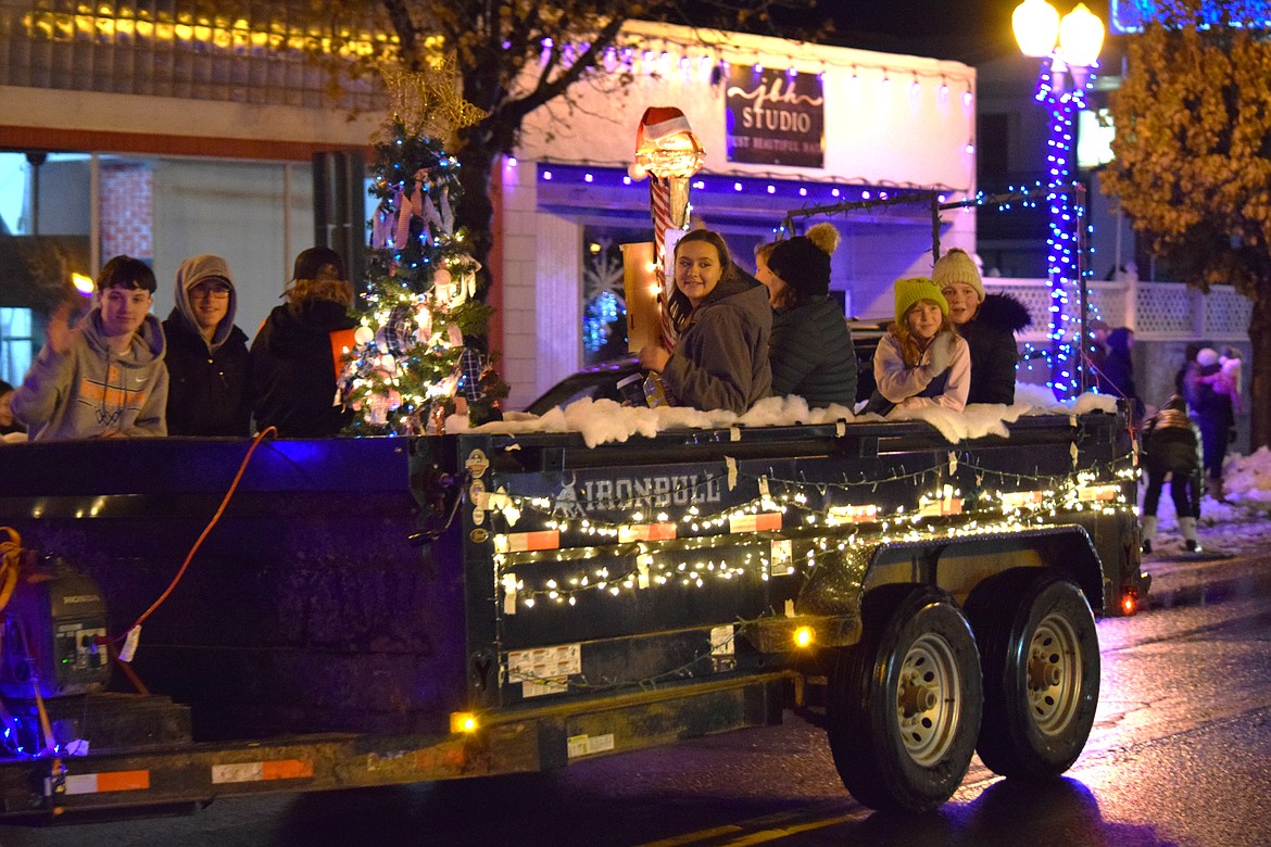 People wave from a float in the Bells on Basin Christmas parade on Saturday in Ephrata.