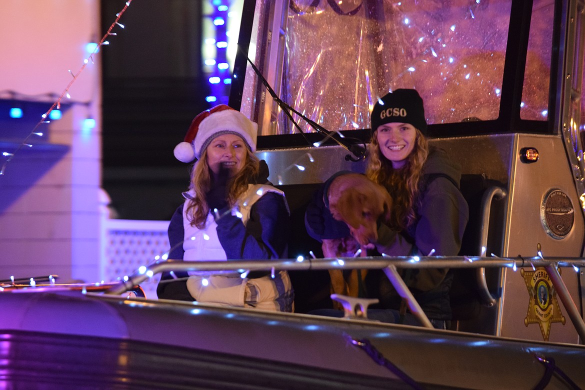 Participants in the Bells on Basin parade in Ephrata wave from the Grant County Sheriff’s Office patrol boat.