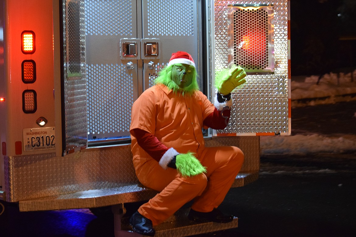 The Grinch sits in an orange, Grant County Jail jumpsuit on the back of the GCSO’s paddy wagon as part of the Bells on Basin parade in Ephrata on Saturday.