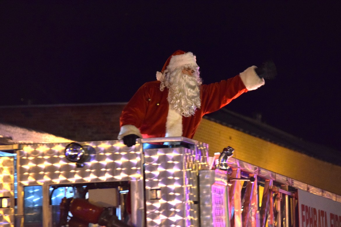 Santa waves from atop an Ephrata Fire Department ladder truck during the Bells on Basin parade in Ephrata on Saturday.