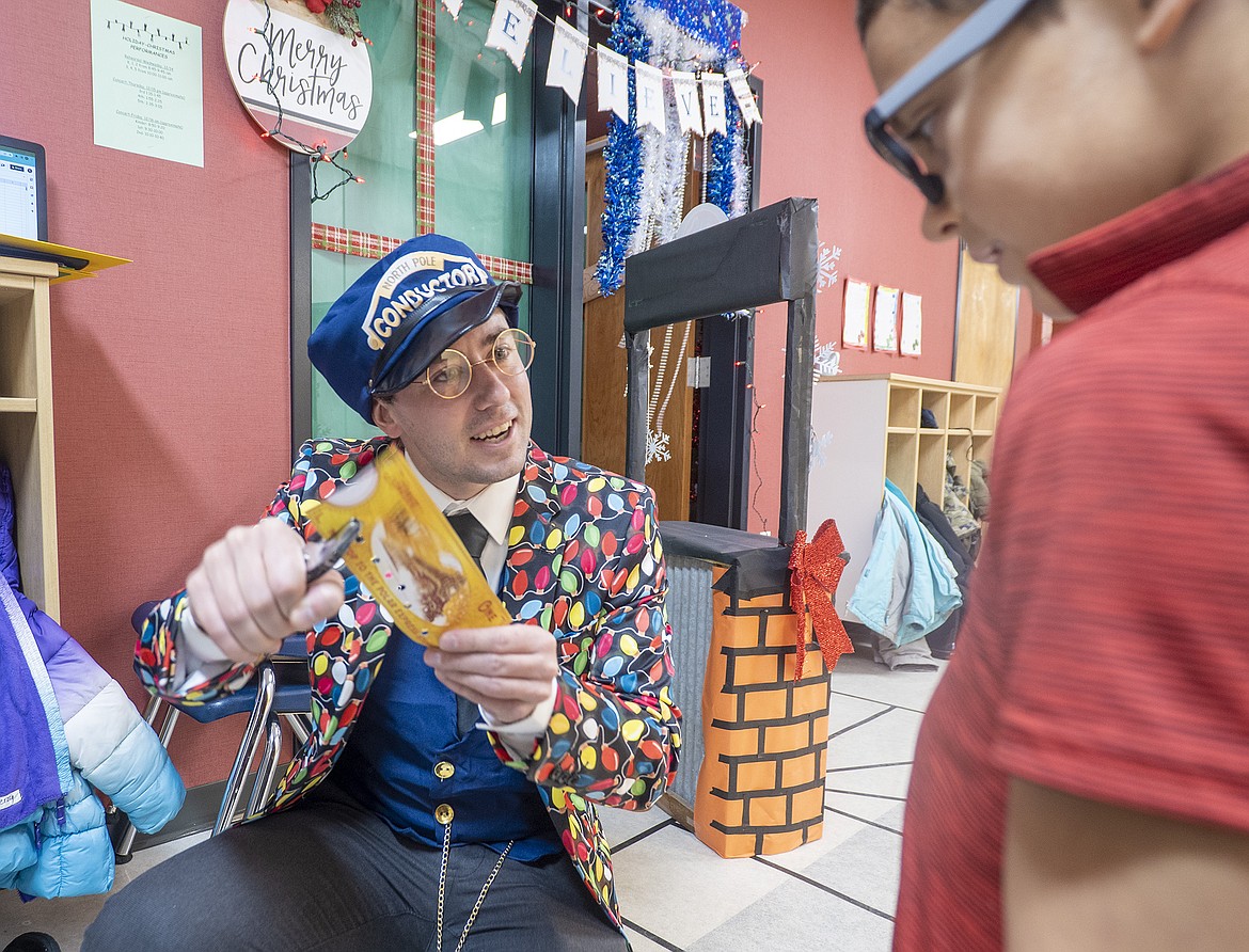 Reid Copeland plays the conductor, punching a ticket for a student visiting the Ruder PTO’s Polar Express Christmas Store last week. (Chris Peterson photo)