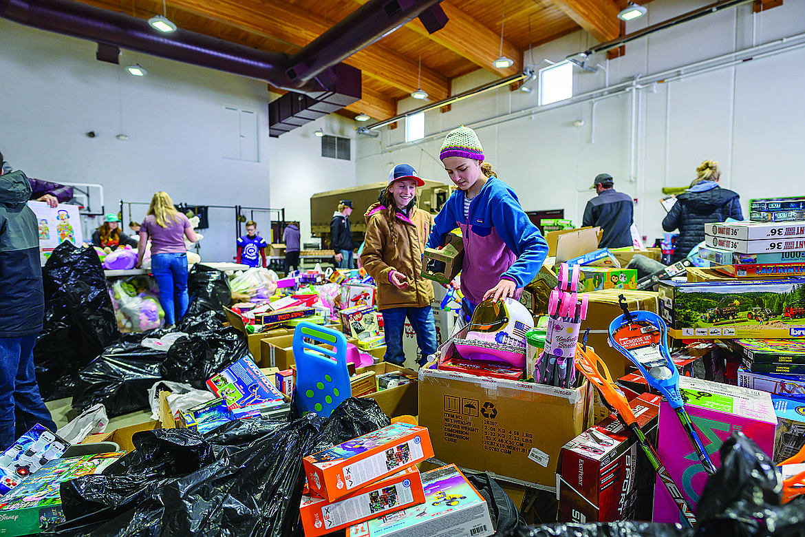 Kensley Heuscher and Madison Peters sort toys for the annual Toys for Tots program at the Kalispell Armory Sunday.