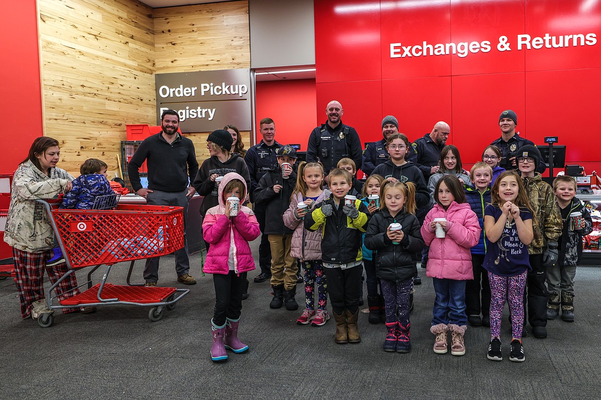 Families and police pose for a photo at Target in Kalispell. The store gives the program a discount on goods. (JP Edge photo)