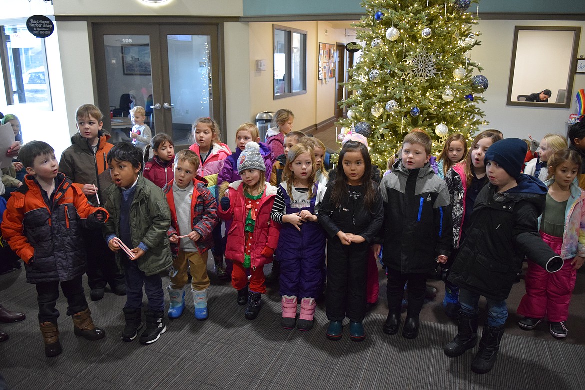 Moses Lake Christian Academy kindergartners sing Christmas carols in front of the Christmas tree in the foyer of the Smith Martin Building in downtown Moses Lake on Wednesday.