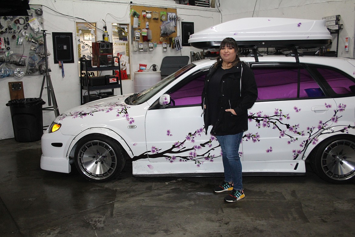 Jessica Preciado with her 2003 Mazda, which her work has turned into a custom car she’s proud of.