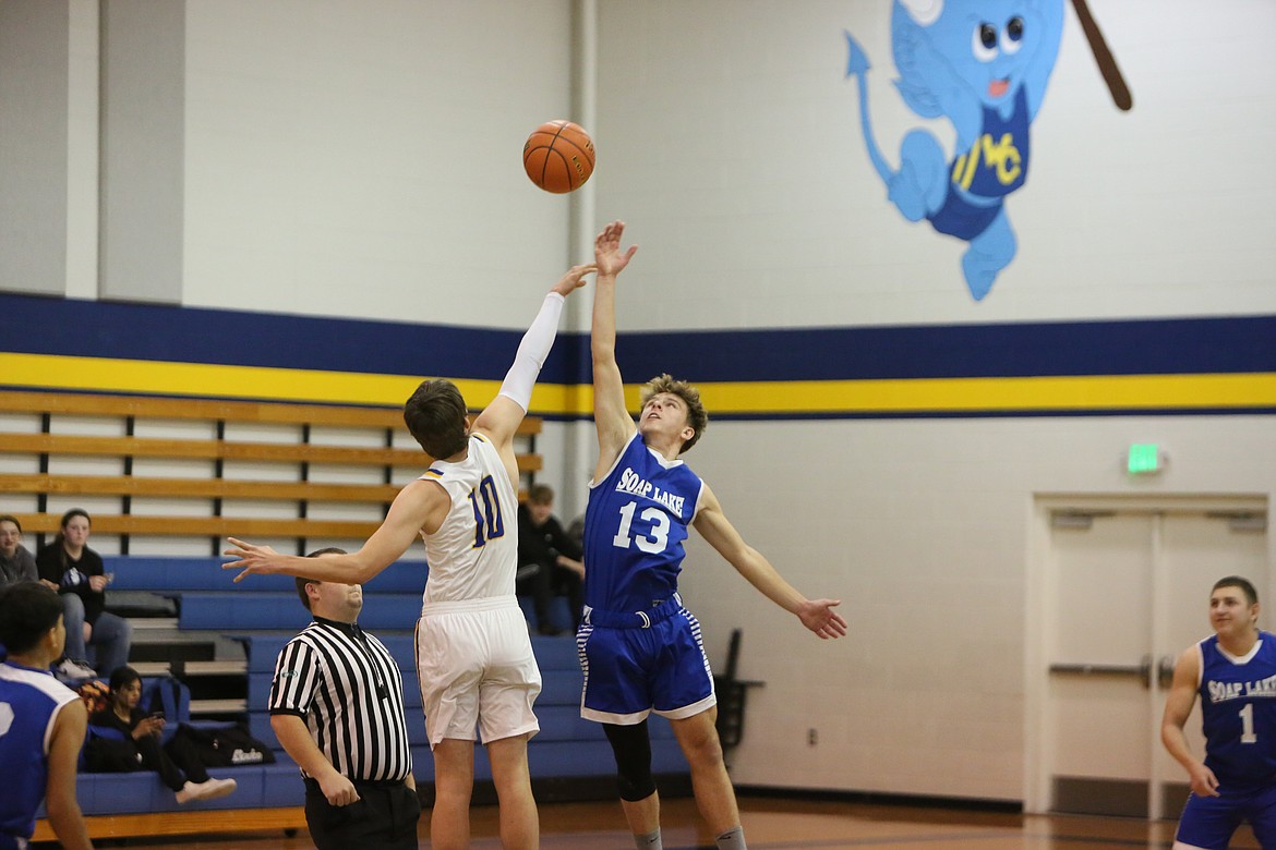 Soap Lake junior Andrey Sushik (13) and Wilson Creek’s Zane McMillan (10) leap up for the opening tipoff.