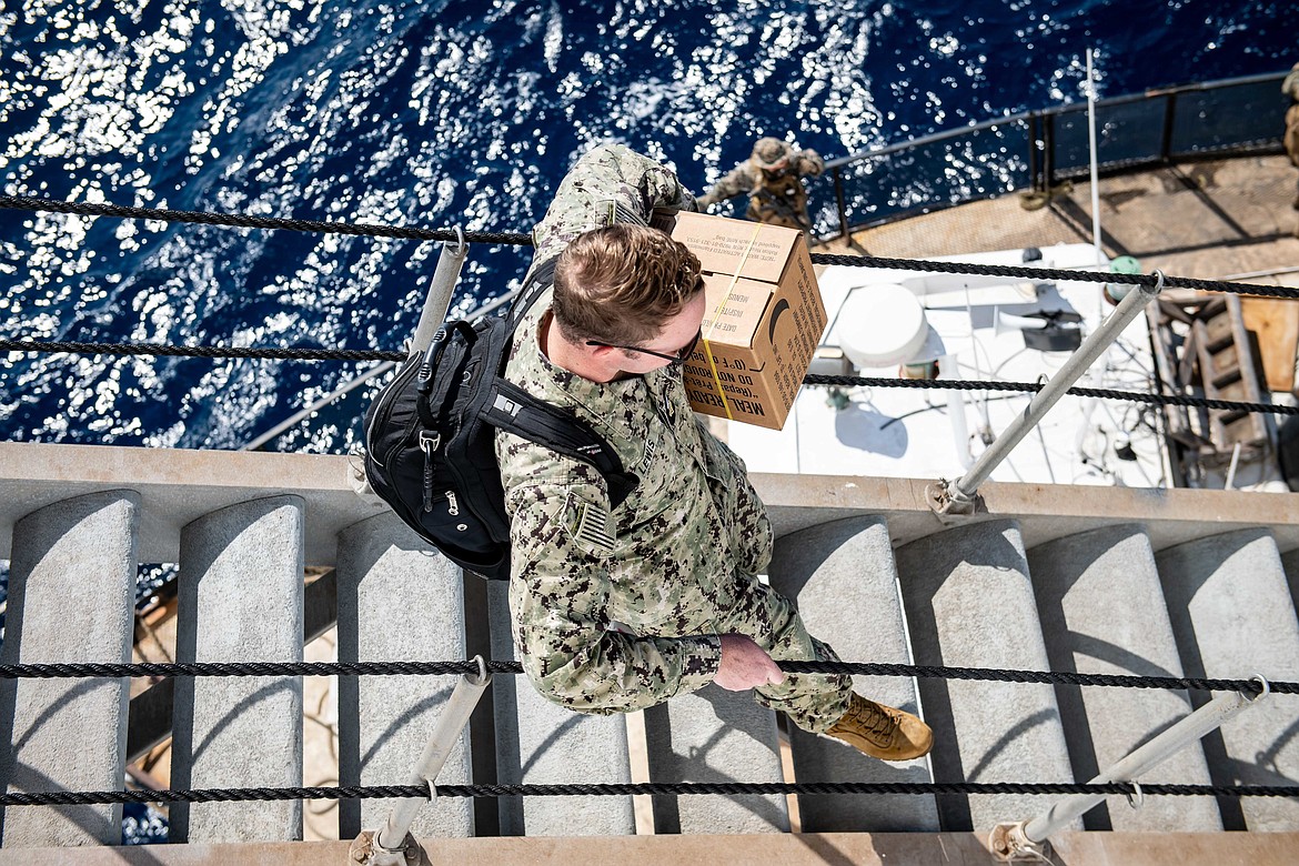 Mass Communication Specialist 1st Class Benjamin Lewis, from Superior, assigned to the hospital ship USNS Comfort, boards a transportation barge to assist in the setup of the medical site in Jeremie, Haiti, Dec. 11. Comfort is deployed to U.S. 4th Fleet in support of Continuing Promise 2022, a humanitarian assistance and goodwill mission conducting direct medical care, expeditionary veterinary care, and subject matter expert exchanges with five partner nations in the Caribbean, Central and South America. (U.S. Navy photo by Mass Communication Specialist 3rd Class Sophia Simons)