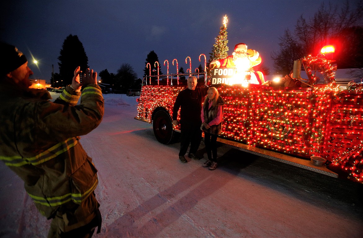 Joe and Anne Sokol pose by the decorated fire truck during the Mobile Santa Food Drive on Monday.