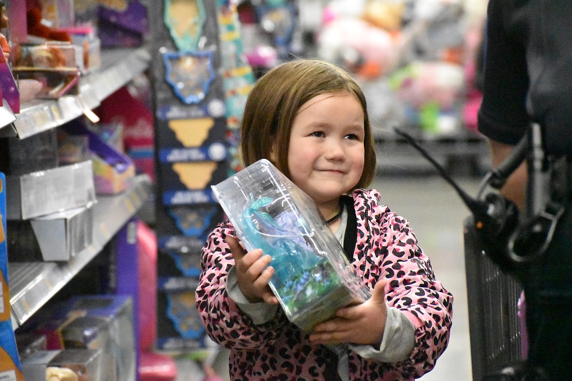 A young shopper shows a law enforcement officer a toy she’s excited about during the Shop with a Cop event held last week. The program is supported by several law enforcement agencies in the area and helps families that are having a hard time have a good Christmas celebration.