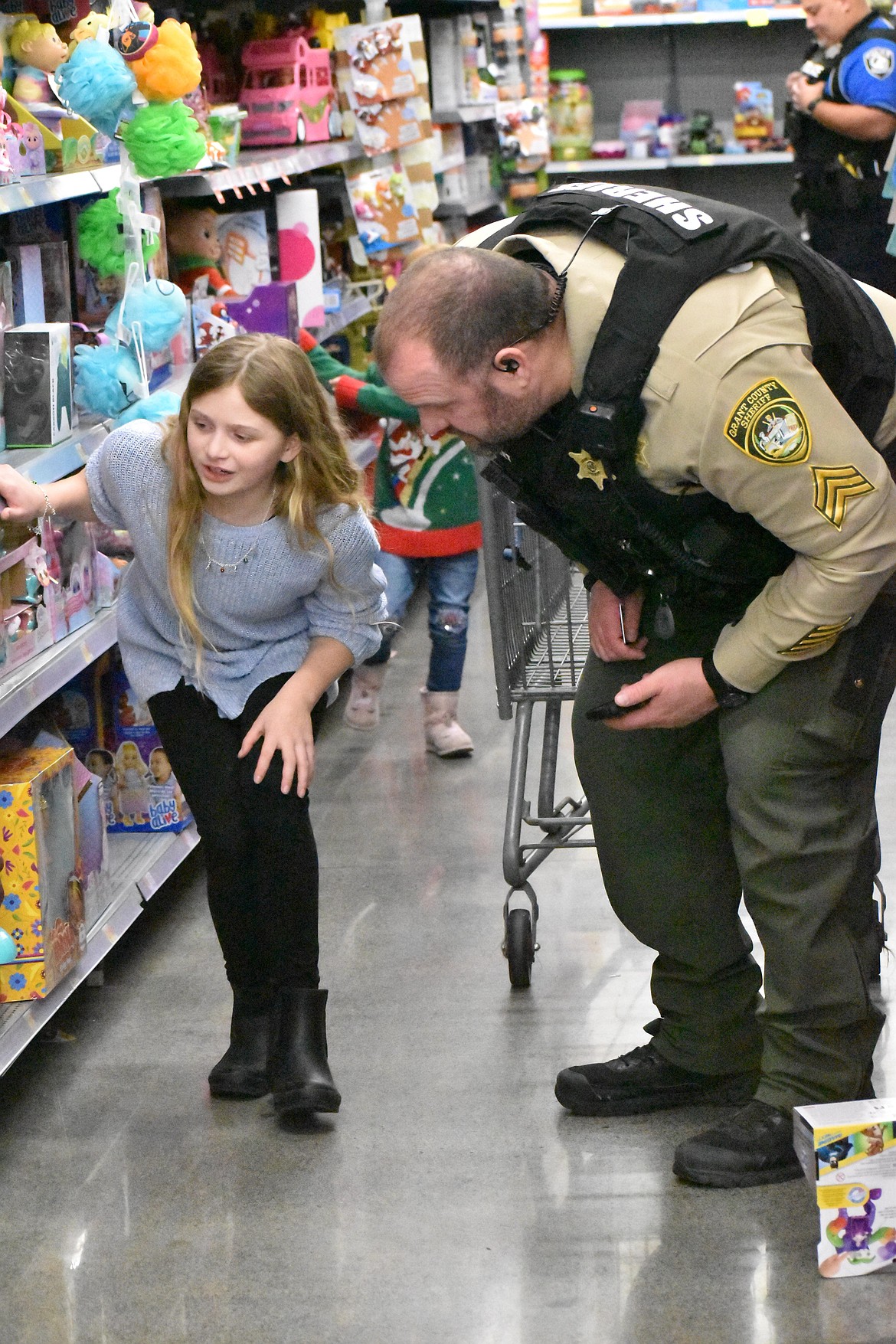 A child and a Grant County Sheriff’s Office deputy look high and low for the perfect gift.