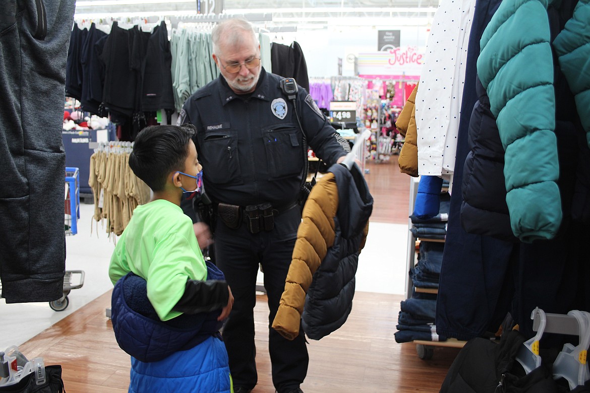 Justin Osorio (left) and his shopping buddy, Othello Police Department Assistant Chief David Rehuame, check out the coats.