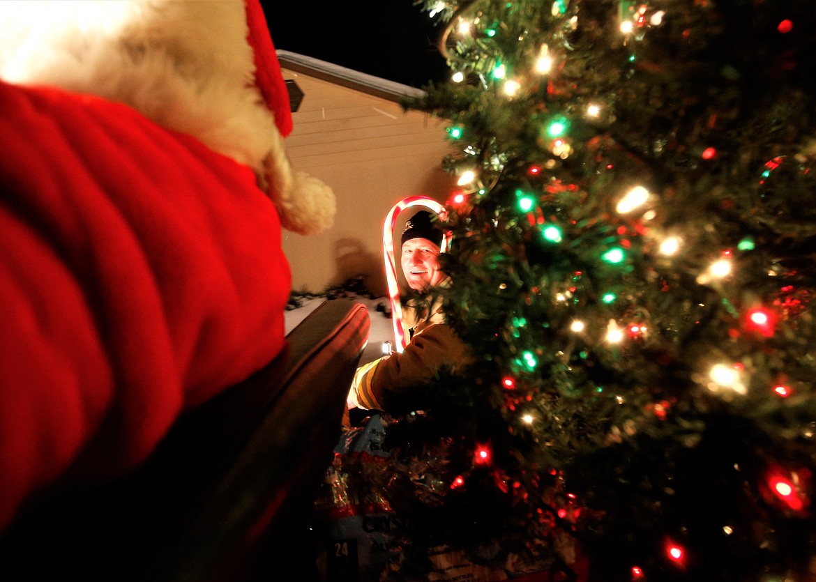 Firefighter Tom Hiltenbrand smiles during the Mobile Santa Food Drive on Monday.