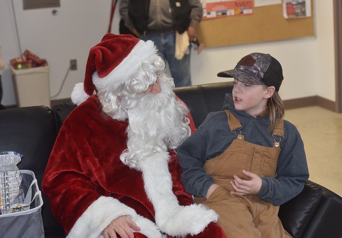 Troy’s Dartanian McBride explains what’s on his wish to Santa Claus Monday afternoon at the Libby Airport. (Scott Shindledecker/The Western News)