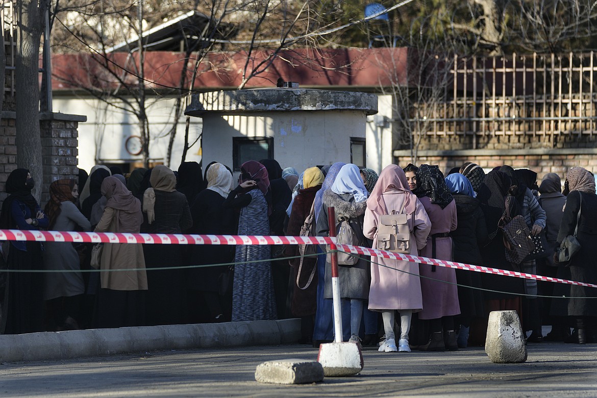 Afghan students queue at one of Kabul University's gates in Kabul, Afghanistan, on Feb. 26, 2022. Women are banned from private and public universities in Afghanistan with immediate effect and until further notice, a Taliban government spokesman said Tuesday, Dec. 20, the latest edict cracking down on their rights and freedoms. (AP Photo/Hussein Malla, File)