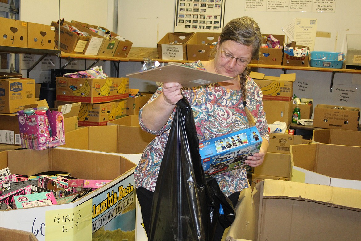 Jeni Roberts adds toys to a bag on Operation Friendship distribution day.