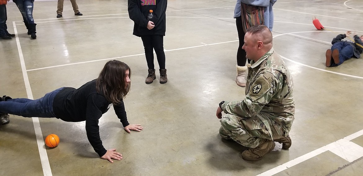 Army National Guard Sgt. Charles Berget emphasizes the importance of physical fitness to an area teen on Dec. 15. (Photo courtesy Jerica O'Neil)
