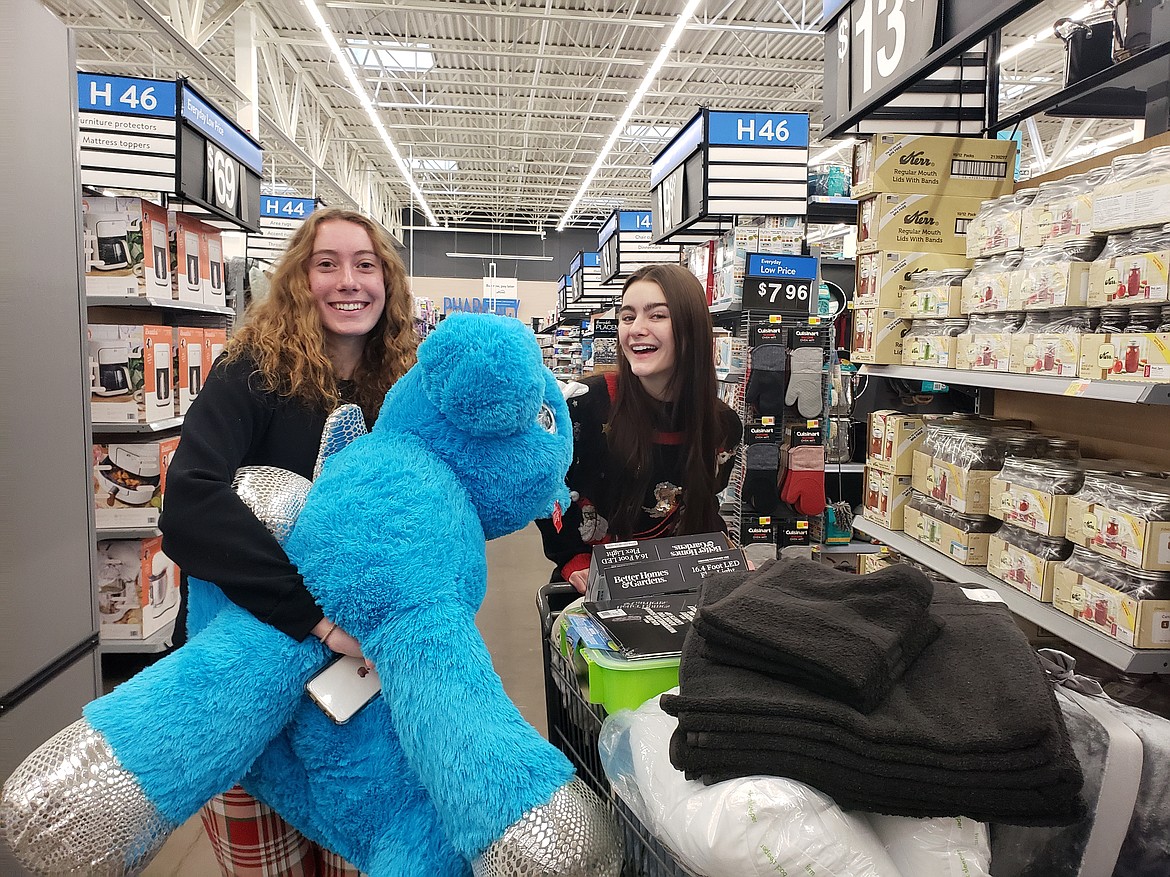 From left, DeLaney Moczan and Alaska Stone gather housewares and a giant stuffed unicorn Wednesday at the Hayden Walmart. Students from the Lake City High School senior economics class raised over $10,500 to shop for select members of the community as part of a real-life budget lesson.