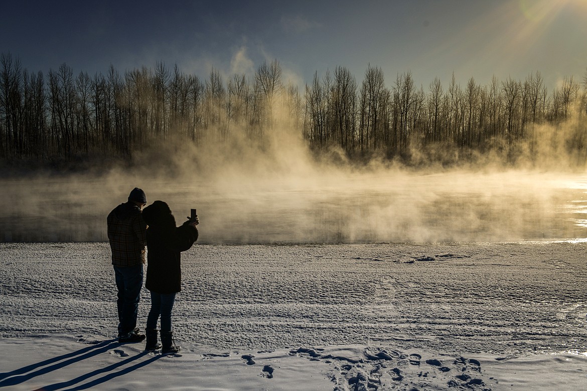 Jerry and Larisa Cuda watch steam rise off the Flathead River on Thursday, Dec. 22. (Casey Kreider/Daily Inter Lake)