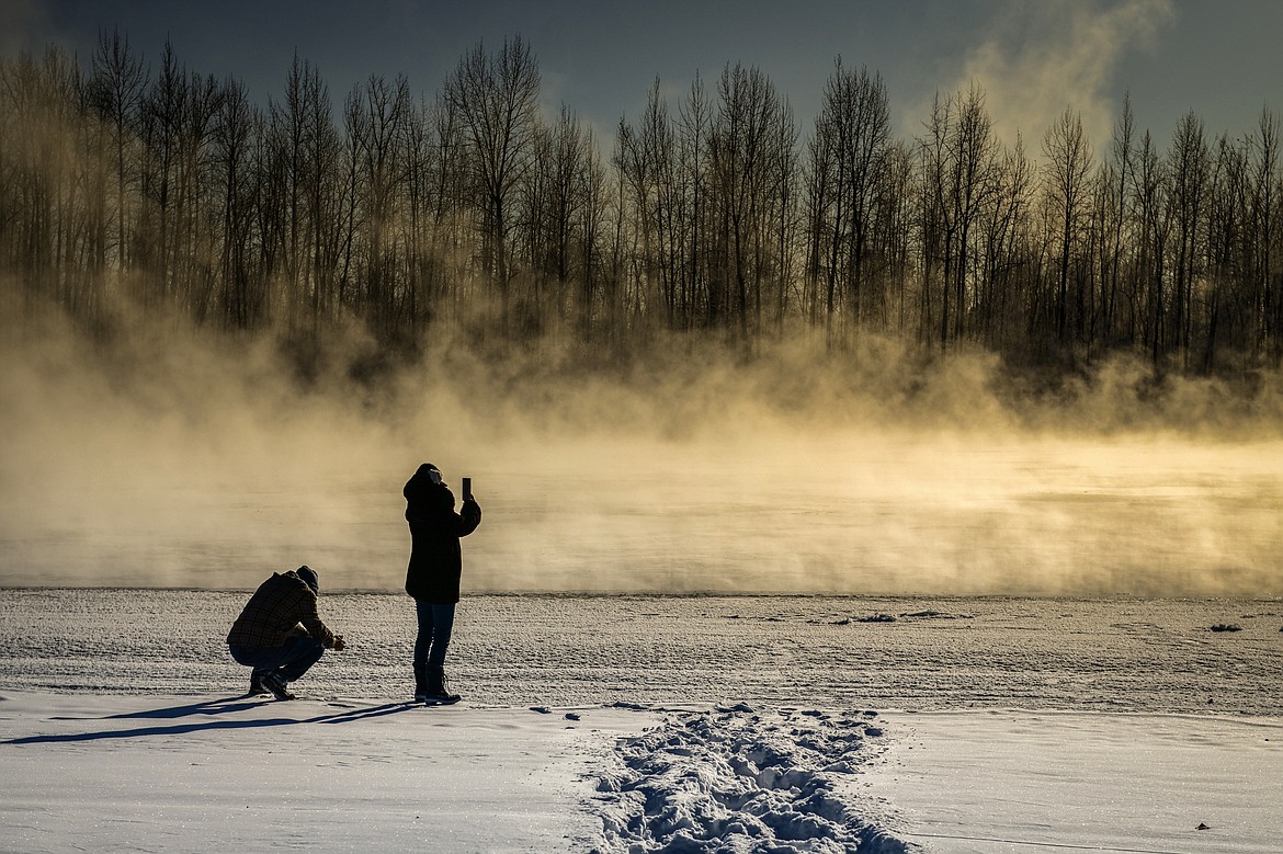 Jerry and Larisa Cuda watch steam rise off the Flathead River on Thursday, Dec. 22. (Casey Kreider/Daily Inter Lake)