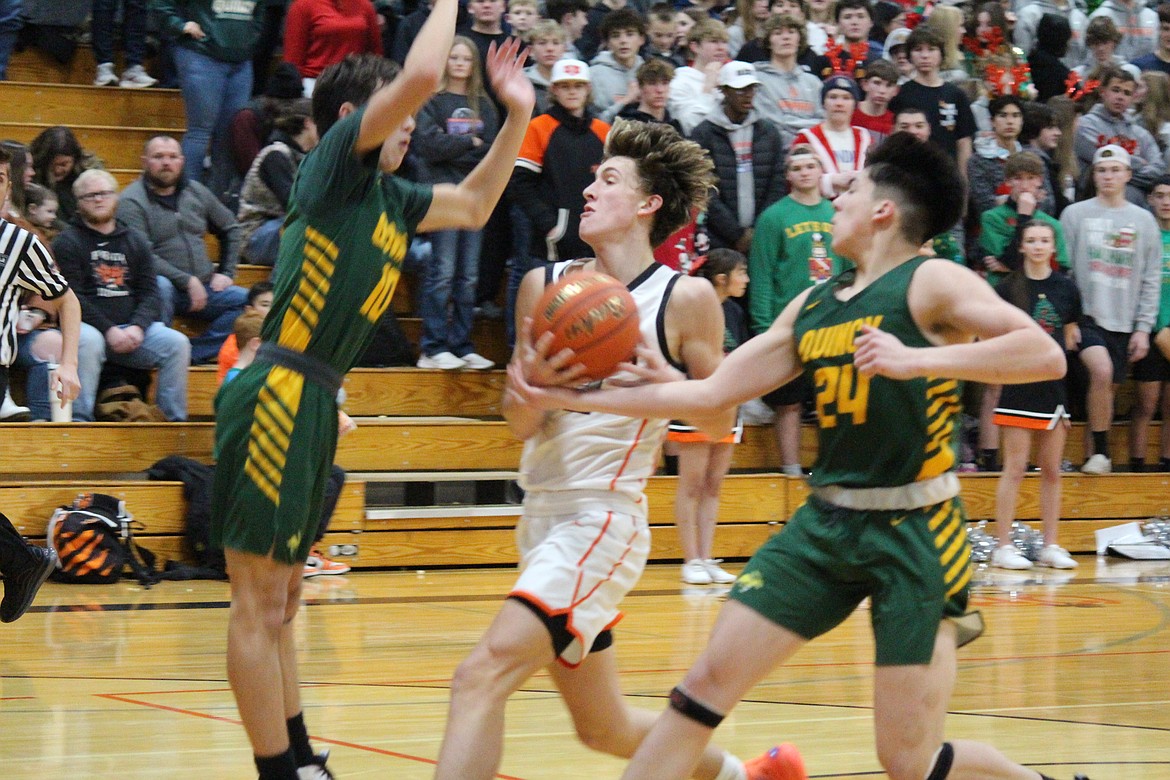 Ephrata’s Hans Roberts, center, splits the defense of Quincy’s Ethan Gregg, left, and Julian Ibarra, right, in Ephrata’s 61-60 win Wednesday.