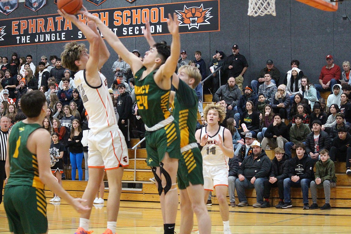 Hans Roberts, left, Ephrata, puts up the shot against Quincy’s Julian Ibarra, right.