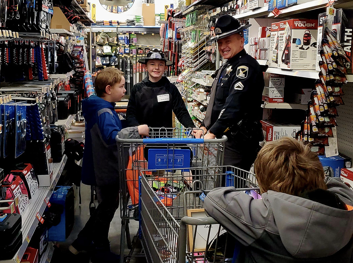 Idaho State Police Trooper Mike Lininger smiles for the camera with his shoppers last weekend.
