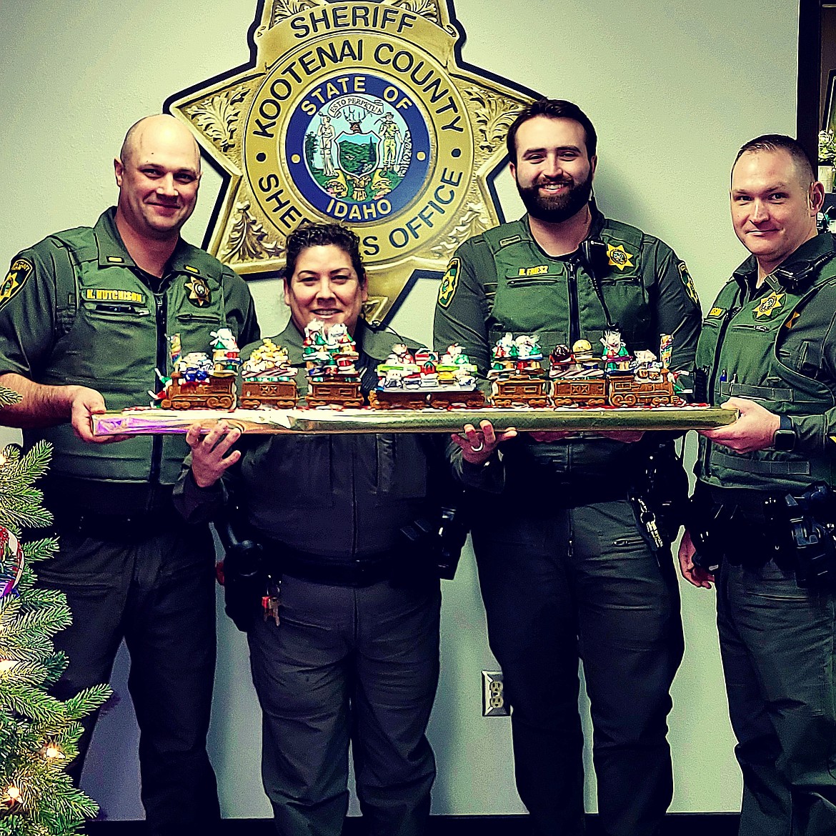 Lt. Hutchison, Deputy Heavey, Deputy Friesz, and Lt. Peterson with the Kootenai County Sheriff's Office proudly display their gingerbread train.