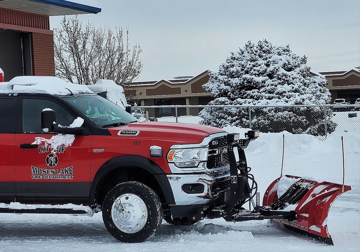 A Moses Lake Fire Department employee uses a department truck with a snowplow to clear snow in front of a fire station earlier this month.