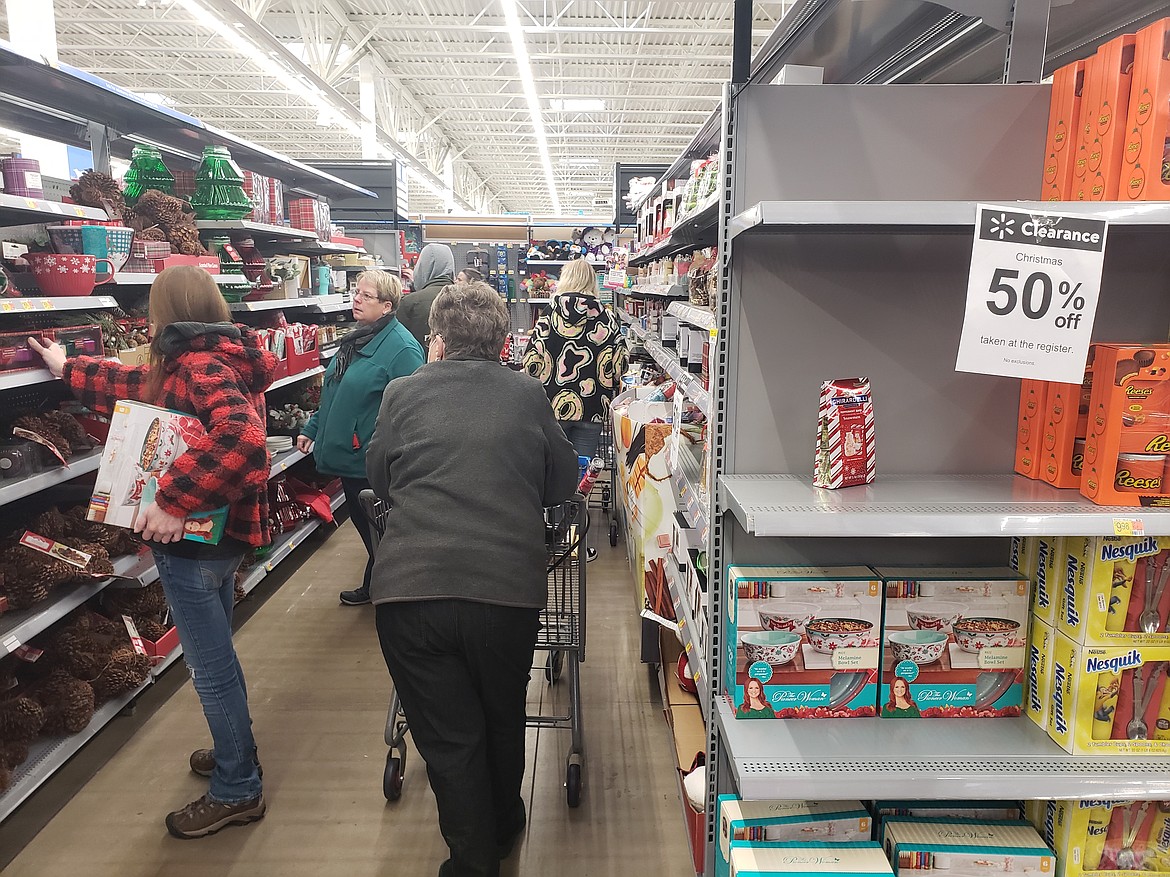 Shoppers fill the aisles at Walmart to take advantage of 50% off sales on Christmas items. Despite price slashing sales, wet weather prevented huge crowds from filling the store on Monday, but the shoppers who did brave the weather got deals on Christmas candy, cards, wrapping paper and more.